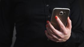 Una mujer sujeta un teléfono móvil / CG