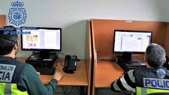 Dos agentes de la Policía Nacional durante la investigación que ha culminado con la desarticulación de un clan en Sabadell dedicado a la falsa venta de caniches por internet /CNP
