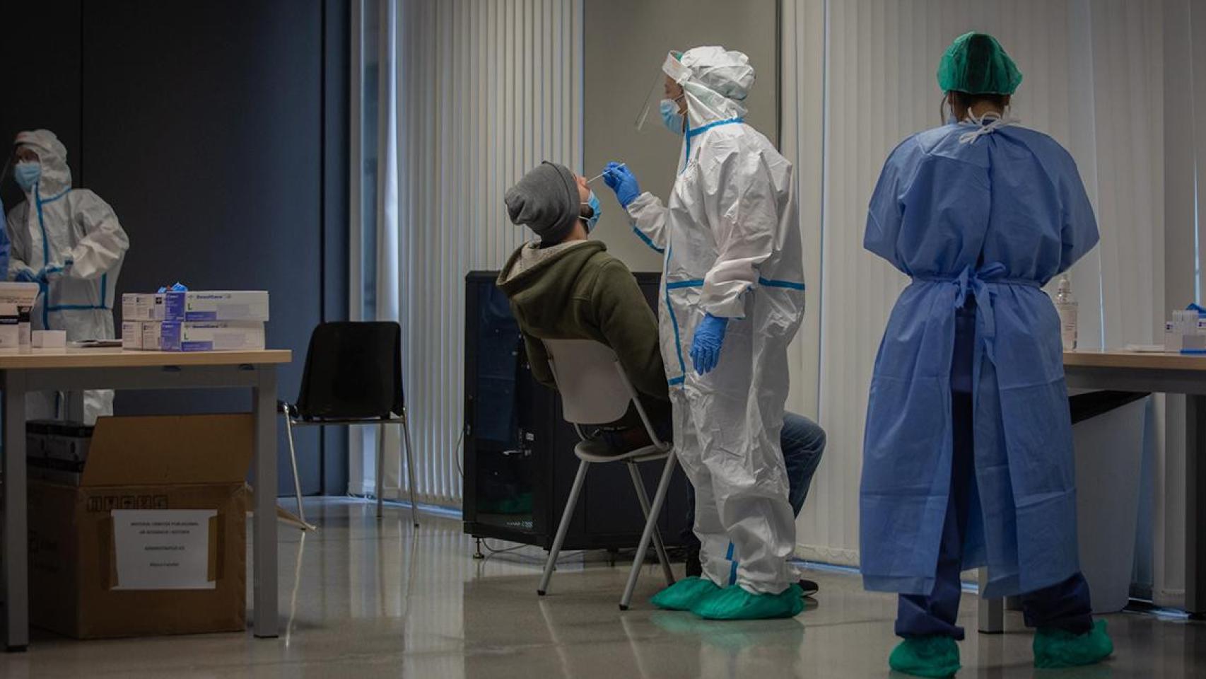 Un hombre recibe una prueba PCR en un dispositivo de cribados masivos en el barrio del Raval, en Barcelona / EUROPA PRESS