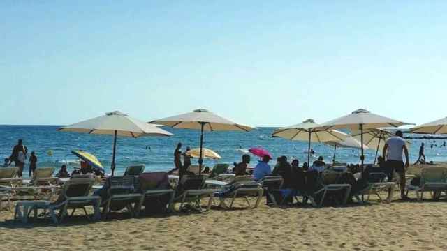 Una zona de playa con hamacas y sombrillas
