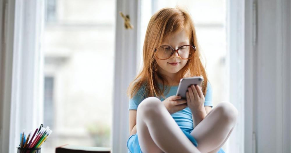 Una niña, utilizando un teléfono móvil / PEXELS