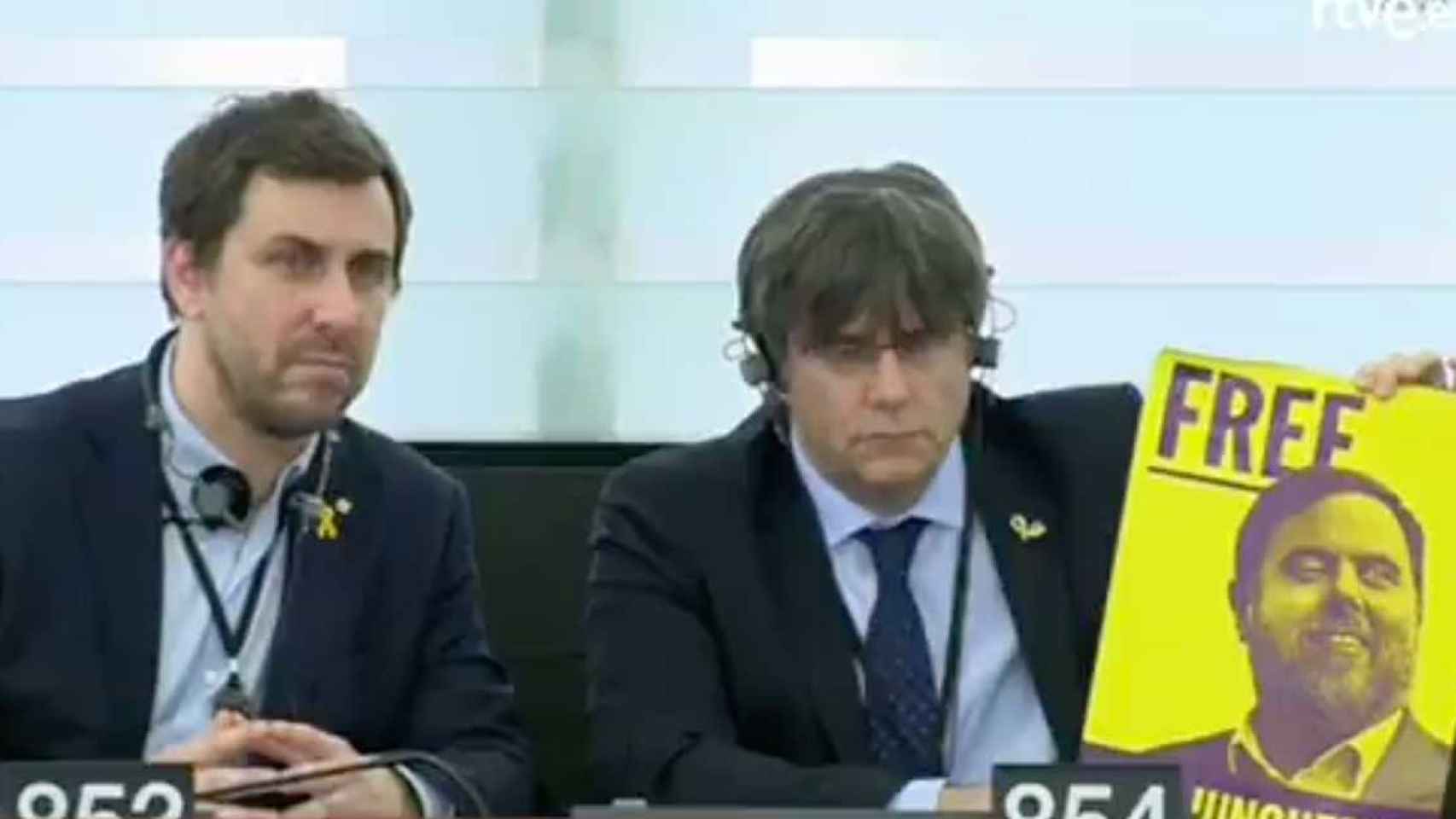 Toni Comín y Carles Puigdemont, mostrando el cartel de apoyo a Junqueras en la Eurocámara / TVE