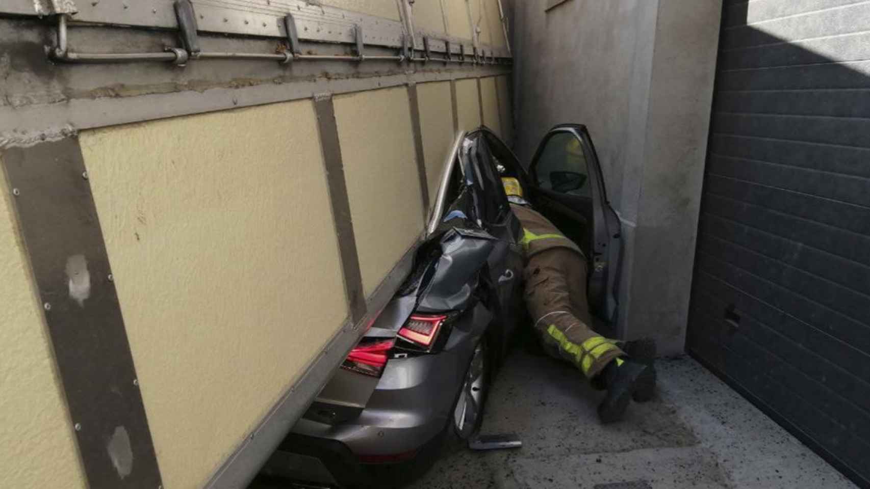 Estado en el que ha quedado el coche tras ser aplastado por un camión / BOMBERS