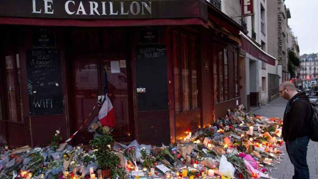 Un parisino observa las flores despositadas ante uno de los restaurantes que fueron objetivo de los terroristas.