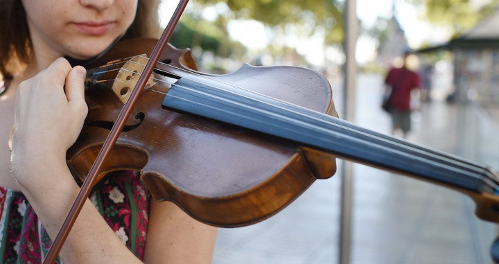 Paula, mientras afina su violín antes de tocar / LENA PRIETO