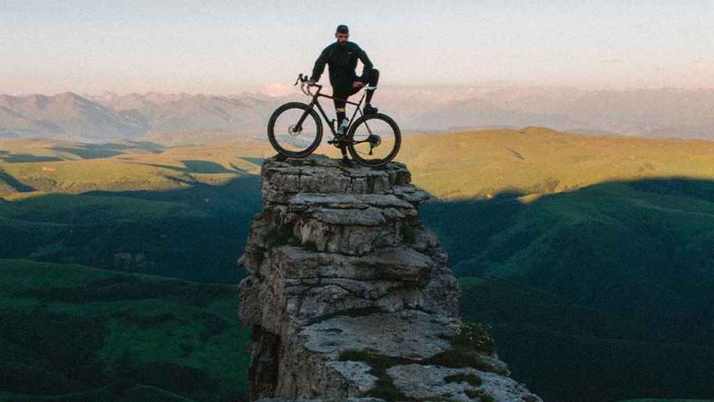 Hombre con bicicleta viajando a un destino de turismo deportivo / UNSPLASH