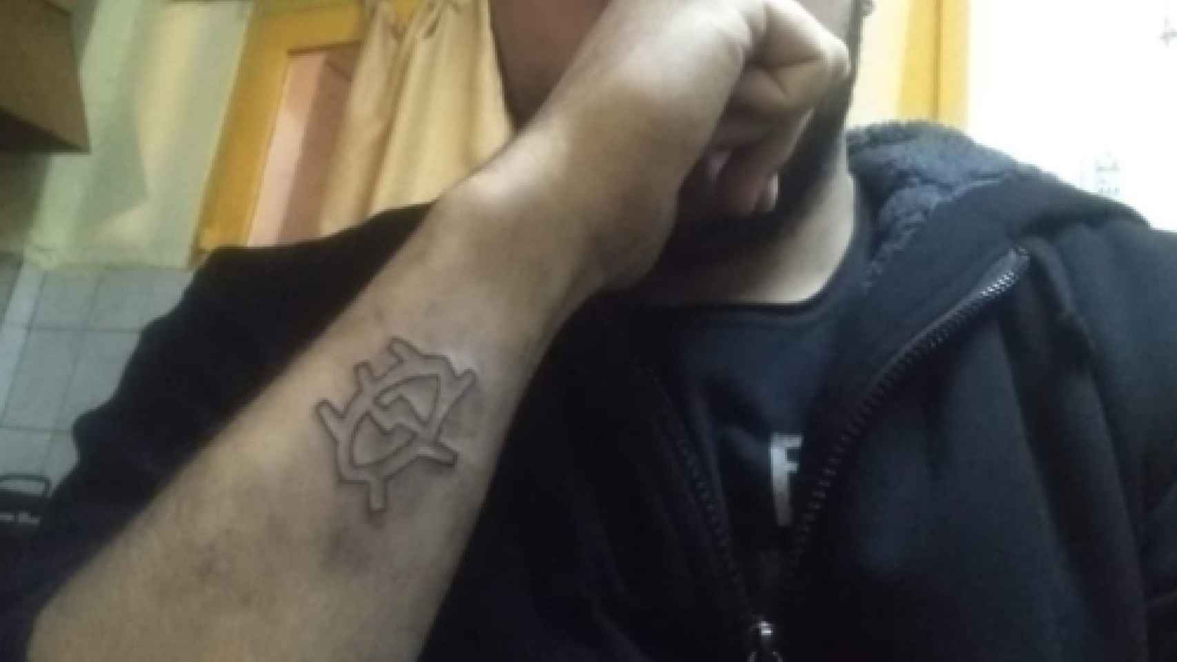 El joven muestra su brazo antes de quitarse el tatuaje con un rallador de queso / TWITTER