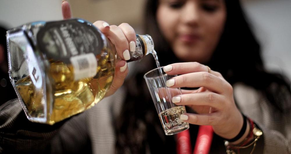 Una mujer sirve tequila en un vaso durante la tercera jornada de la Feria Internacional de Turismo / FITUR 2020