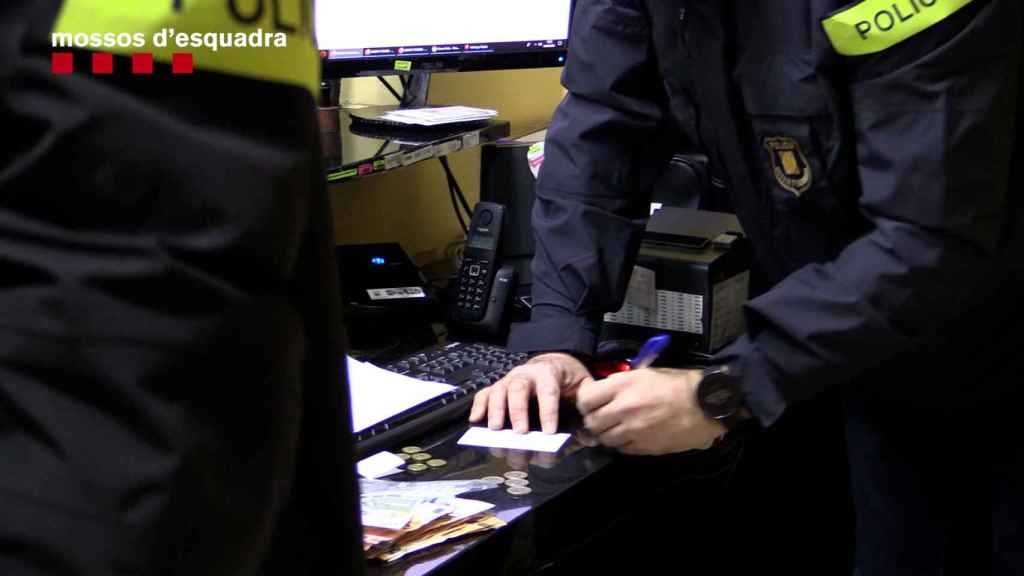 Agentes de los Mossos d'Esquadra durante el registro efectuado en 29 locales dedicados a la venta ilegal de lotería dominicana / MOSSOS