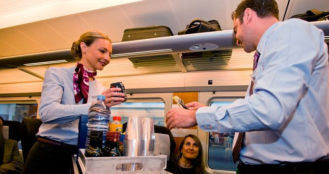 Trabajadores del Ave sirviendo bebidas a los pasajeros / CG