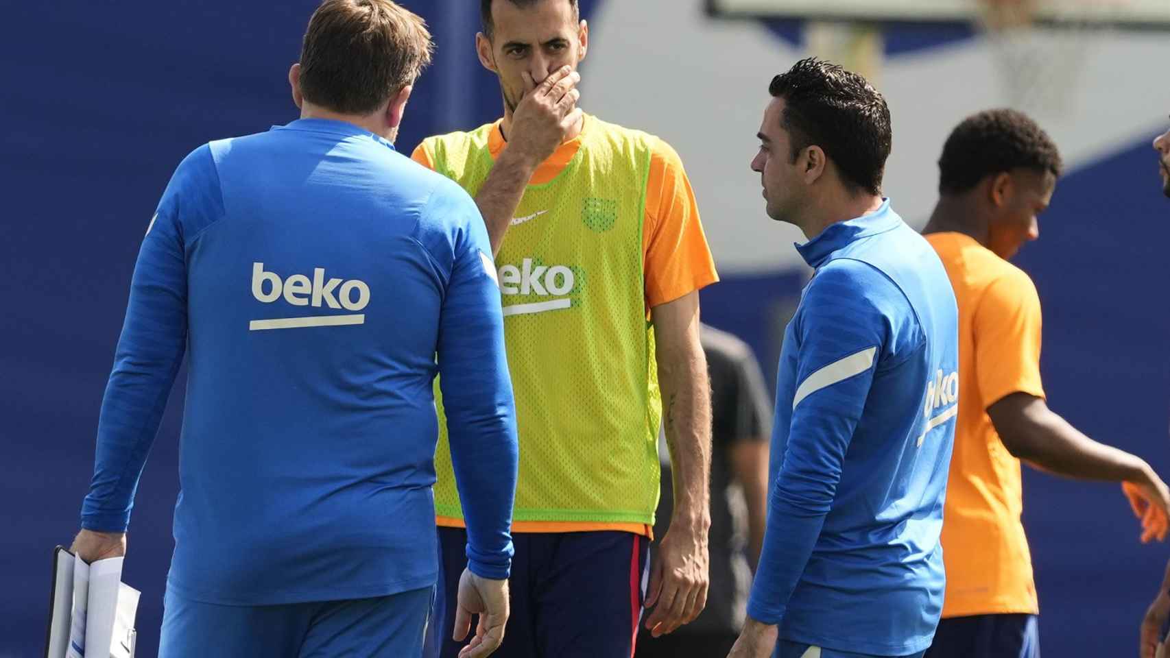 Xavi se dirige a Sergio Busquets en el entrenamiento del sábado / EFE