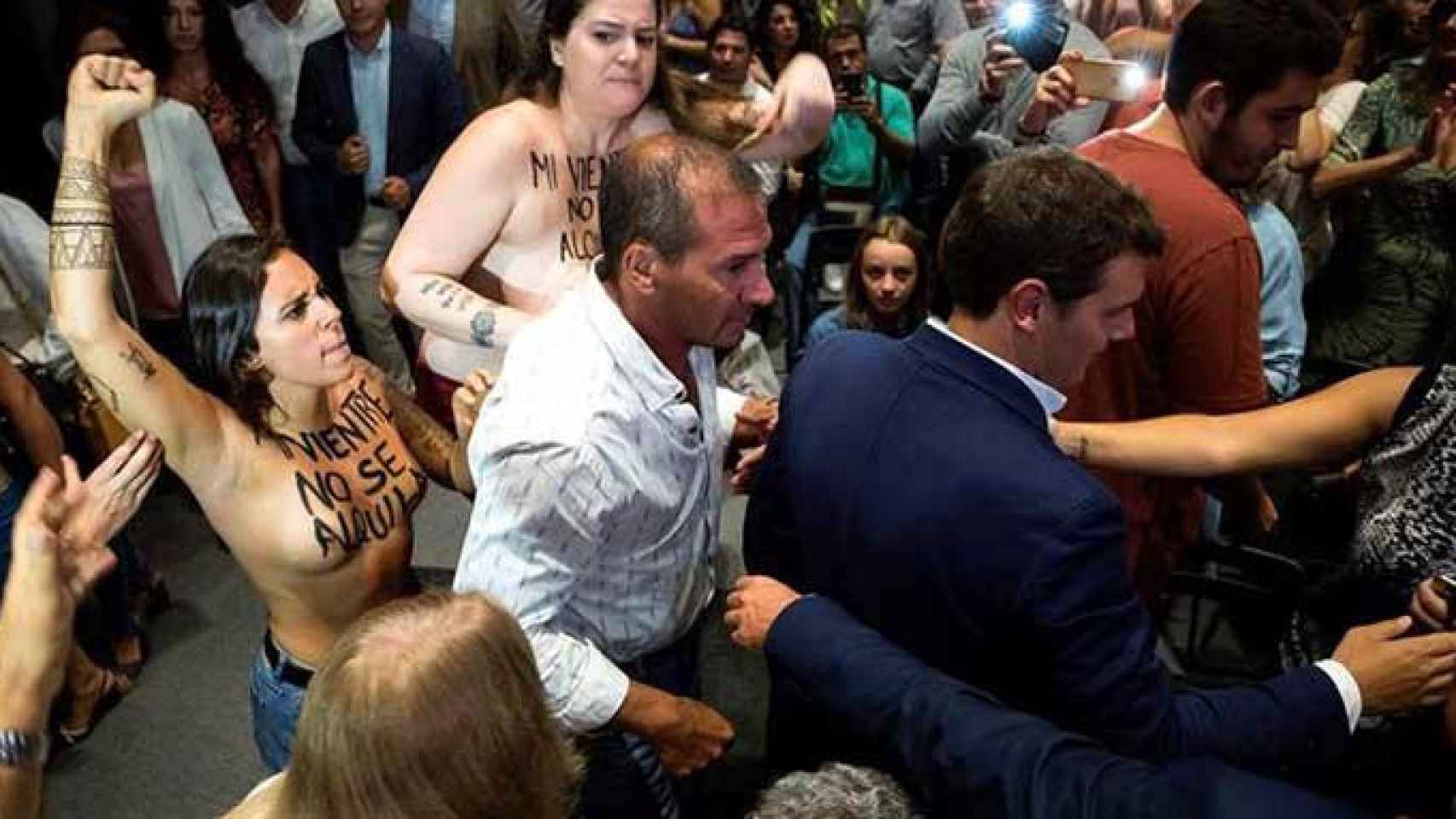 El presidente de Ciudadanos, Albert Rivera (d), sorprendido por una protesta del grupo feminista Femen, a su llegada a un acto en Málaga / EFE