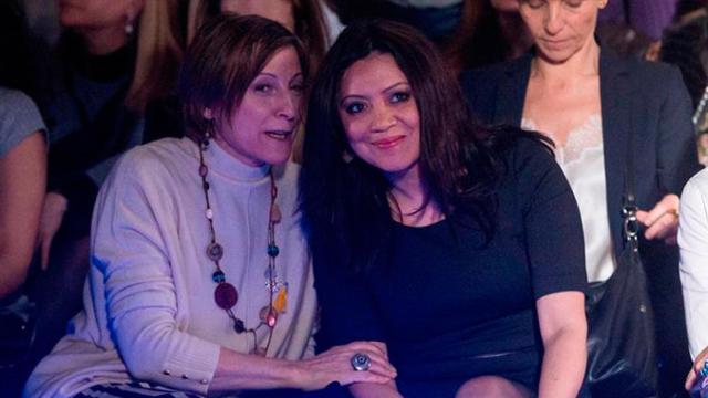 La expresidenta del parlamento de Cataluña Carme Forcadell (i) comenta con la esposa del expresidente de la Generalitat cesado Carles Puigdemont, Marcela Topor (d), una de las creaciones de Miquel Suay en la 080 Barcelona Fashion / EFE