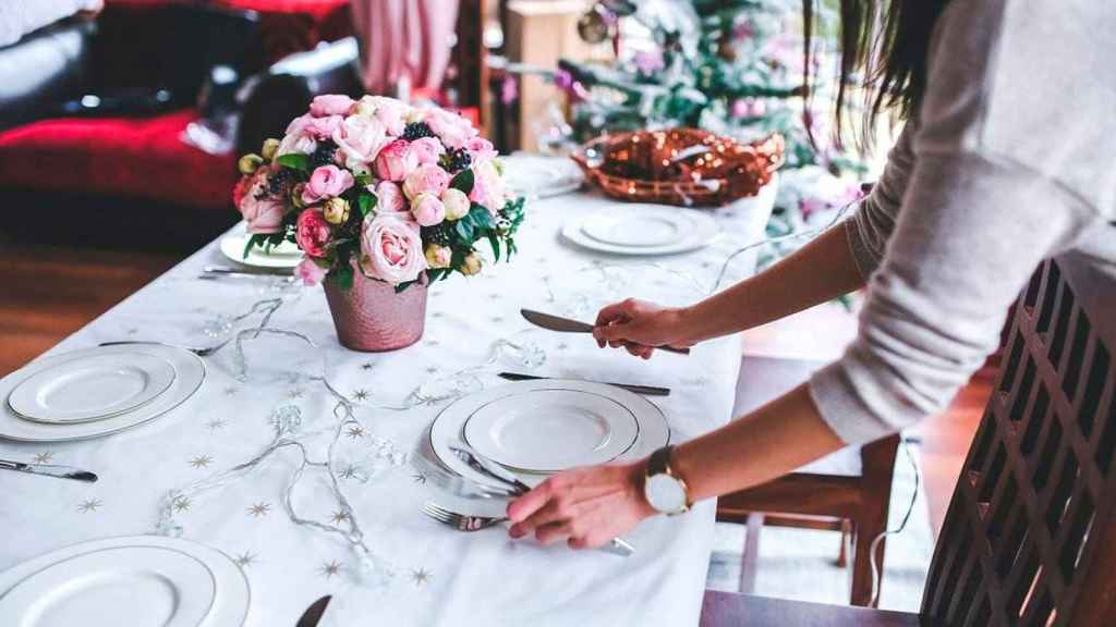 Una mujer prepara la mesa en Navidad / Pixabay