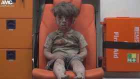 Omar Daqneesh espera en la ambulancia tras ser rescatado entre las ruinas de un edificio derrumbado por un bombardeo en Alepo, Siria. / CG