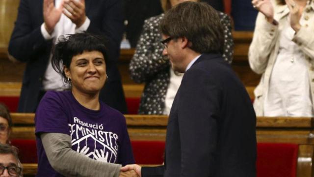 El 'president' de la Generalitat, Carles Puigdemont, tiende la mano a la diputada de la CUP, Anna Gabriel / EFE