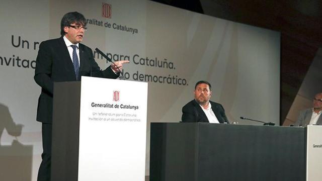El presidente de la Generalitat, Carles Puigdemont, acompañado por el vicepresidente, Oriol Junqueras, y el consejero de Exteriores, Raül Romeva, durante su conferencia de este lunes en Madrid / EFE