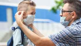 Un padre y un hijo usando mascarillas / EP