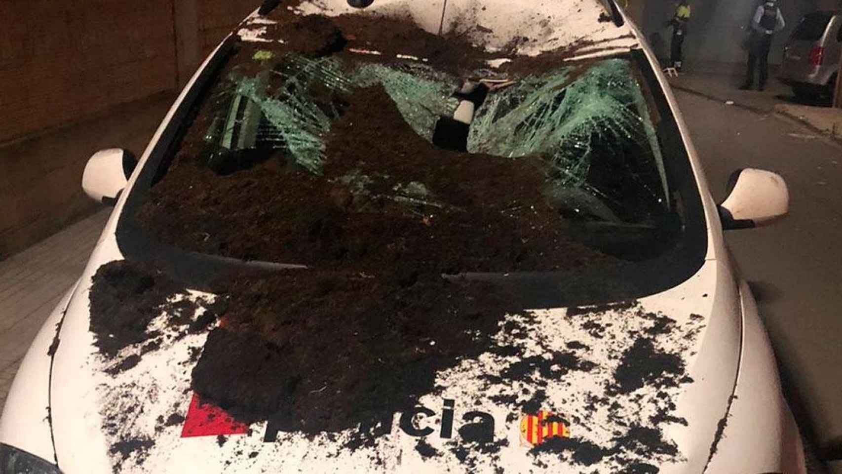 El coche patrulla destrozado por el lanzamiento de macetas y objetos / MOSSOS