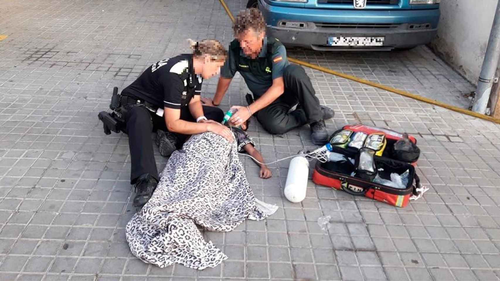 Dos agentes de la Guardia Civil atienden a un niño afectado por el incendio de un piso en Pineda de Mar / EP