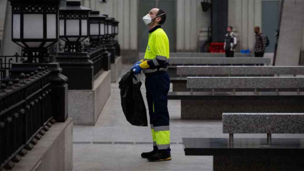 Un trabajador de la limpieza trabaja protegido con una mascarilla / EUROPA PRESS