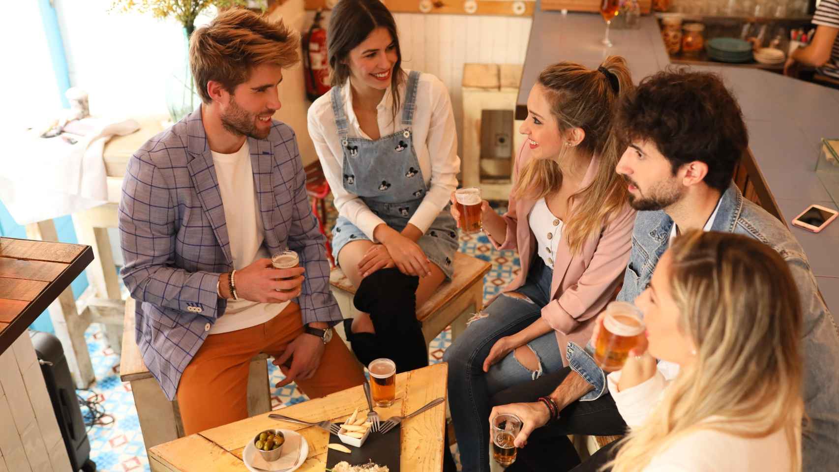 Imagen de varias personas bebiendo cerveza en un bar / CERVECERAS DE ESPAÑA