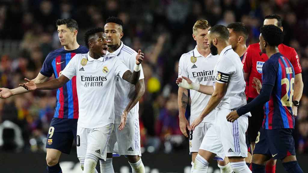 Vinicius discute con varios jugadores del Barça antes de salir del campo / EFE