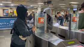 Dos jóvenes enmascarados de Batec, abriendo los tornos de la estación de Renfe en Plaza Catalunya / TWITTER