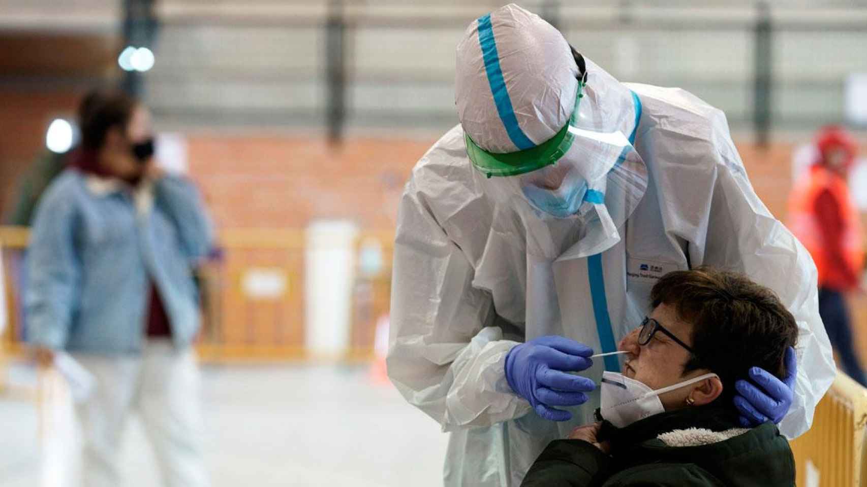 Imagen de un sanitario llevando a cabo un test PCR a una paciente, el sector en el que los recortes son alarmantes según Amnistía Internacional / EFE