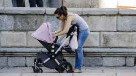 Madre con un carrito en la calle / EFE