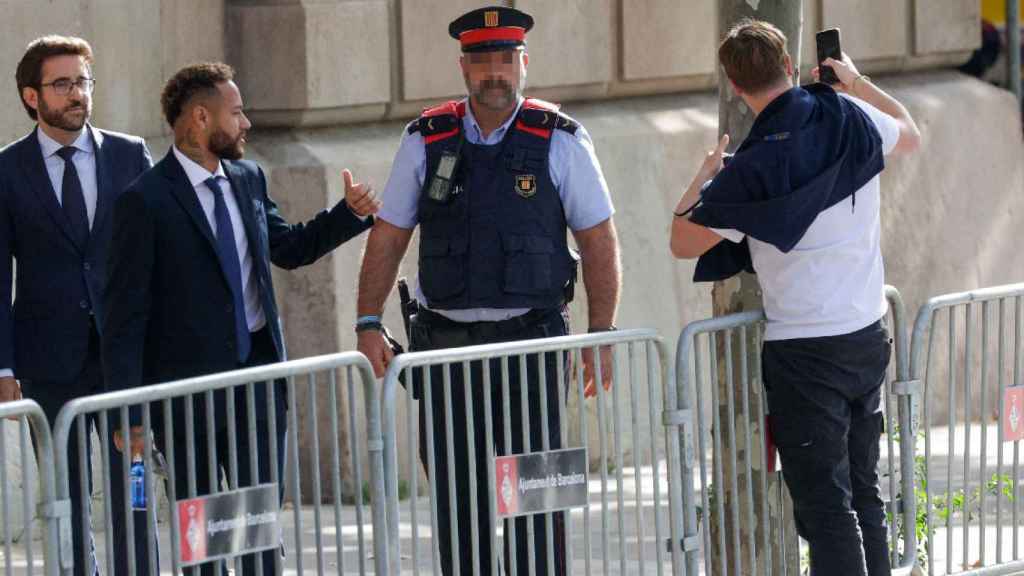 Neymar Jr. posa con un fan a las puertas de la Audiencia de Barcelona, donde este martes Cury ha desmentido a Florentino Pérez / QUIQUE GARCÍA - EFE