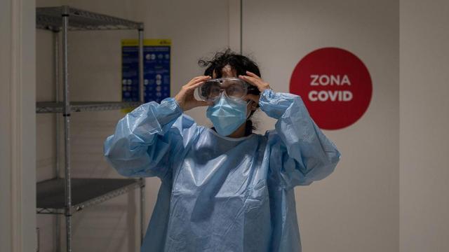 Una profesional sanitaria se viste con un epi en el edificio Garbí-Vall de Hebrón, en Barcelona / DAVID ZORRAKINO - EUROPA PRESS