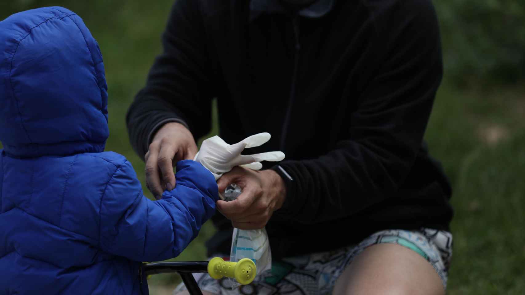 Un padre coloca guantes a su hijo para salir a la calle / EUROPA PRESS