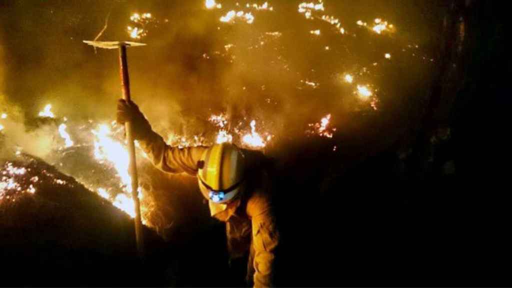 Un bombero trabajando en las labores de extinción del incendio de La Palma la madrugada del sábado.