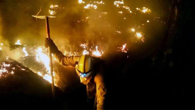 Un bombero trabajando en las labores de extinción del incendio de La Palma la madrugada del sábado.