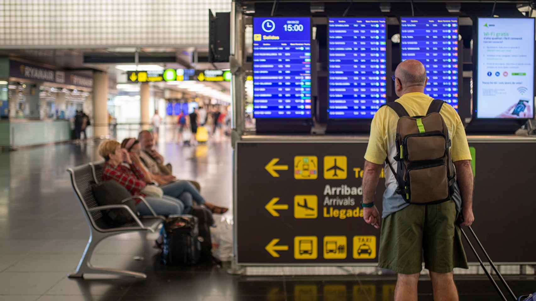 Un hombre mira un panel de llegadas y salidas en el aeropuerto de El Prat, que sufre la huelga aérea de Francia / EUROPA PRESS