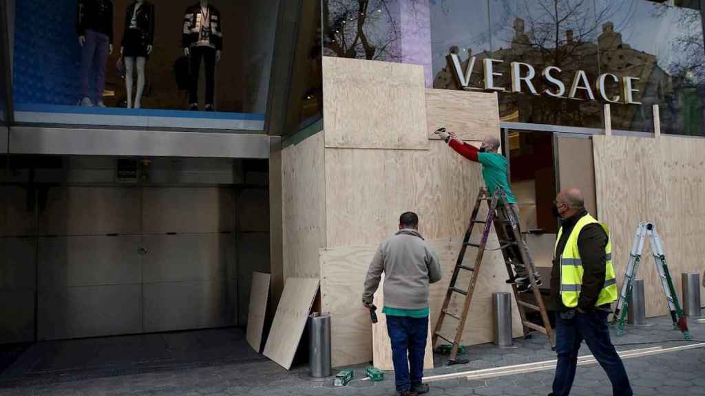 Los operarios reparan los destrozos de la tienda de Versace en Paseo de Gracia / EFE