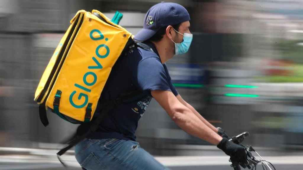 Un repartidor de Glovo ataviado con mascarilla, durante un servicio / EP