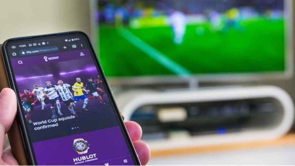 Móvil, televisor y retransmisión de fútbol