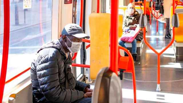 Dos pasajeros de transporte público usan mascarilla para evitar contagios del coronavirus / EP