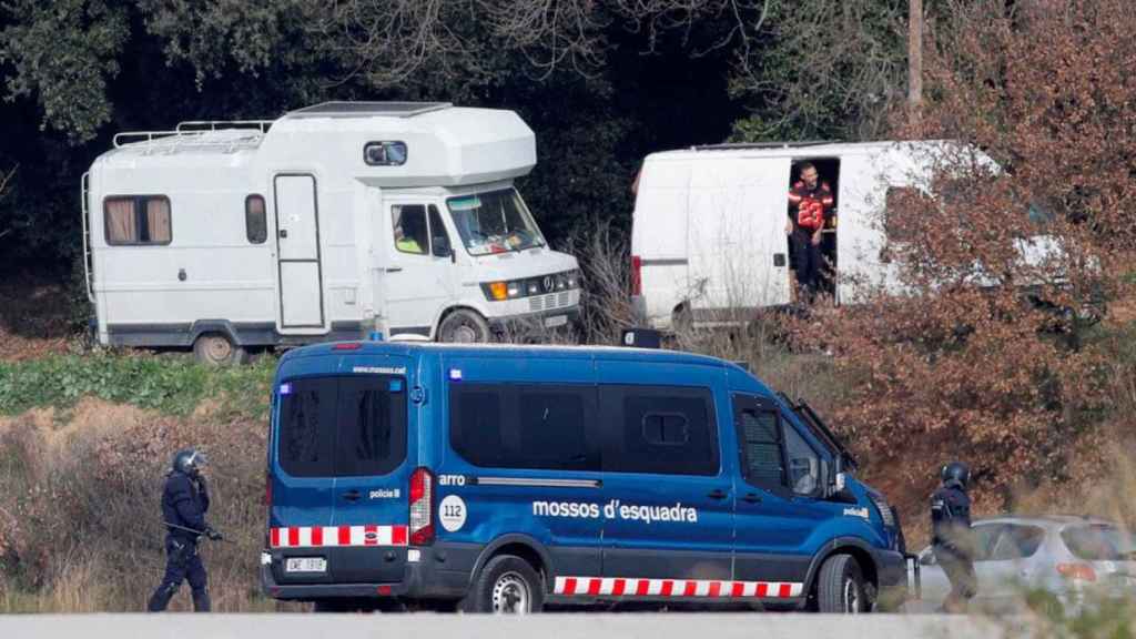 Una furgoneta de los Mossos d'Esquadra, ante participantes en la 'rave' de Llinars / EFE