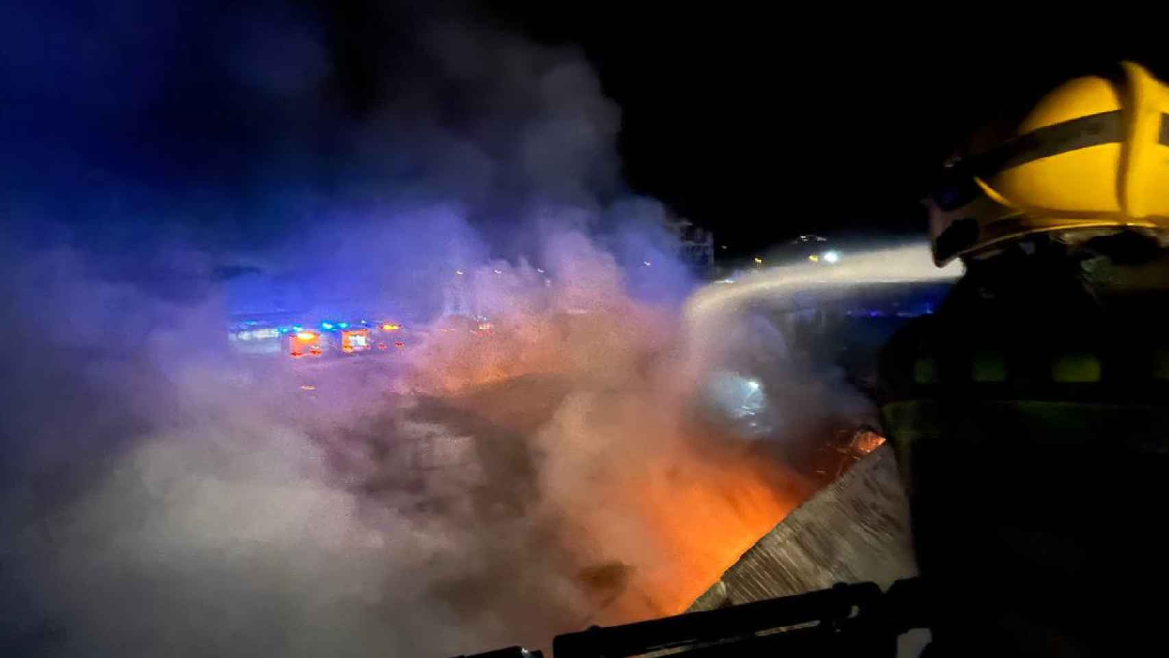 Un bombero trabaja en las labores de extinción de un incendio en una fábrica de La Llagosta, que ha obligado a activar la alerta química / BOMBERS