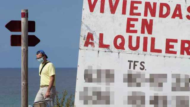 Un ciudadano camina junto a un cartel de viviendas en alquiler / EP