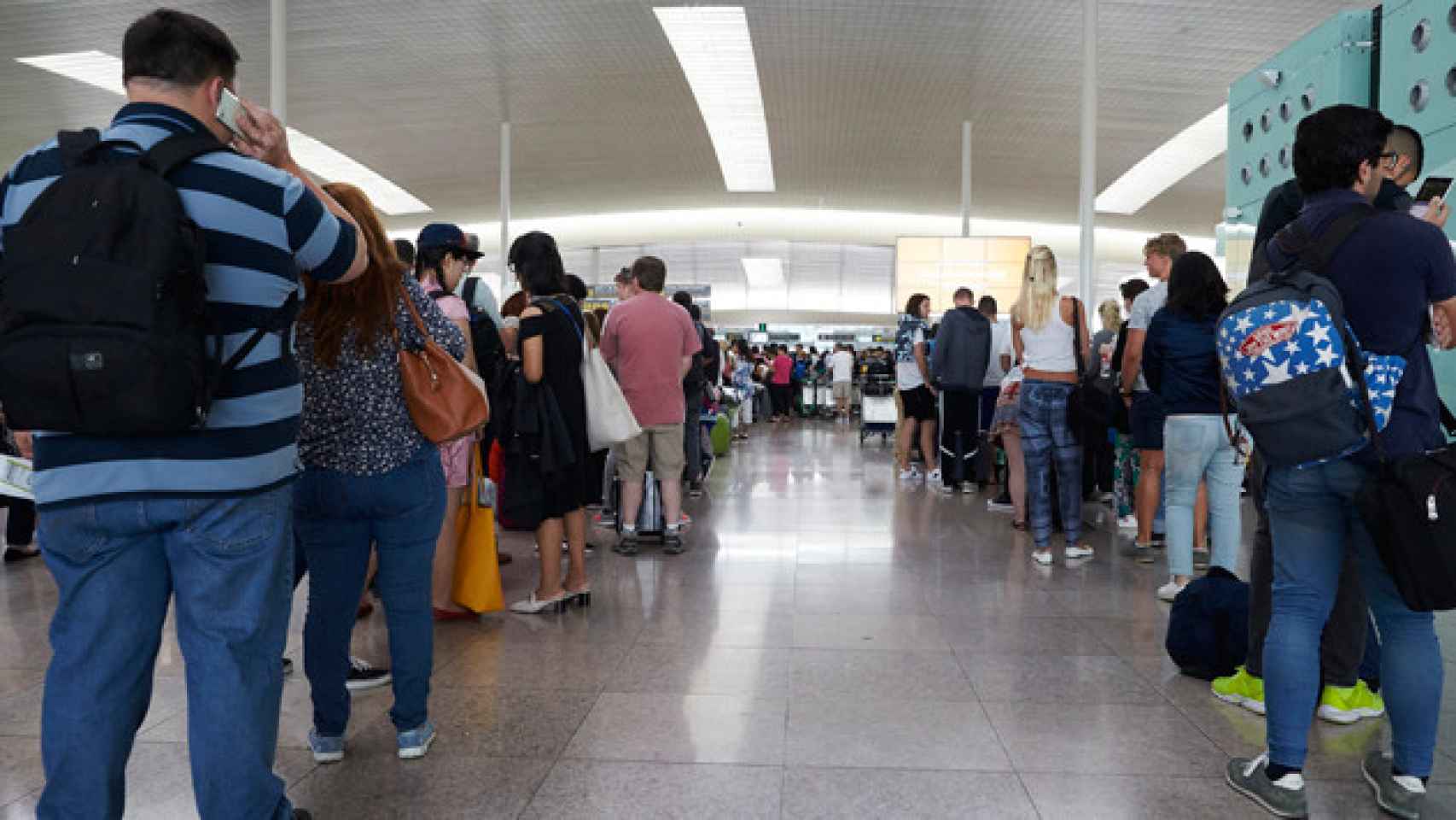 Pasajeros en una cola de acceso a los controles de seguridad del aeropuerto de El Prat / EFE