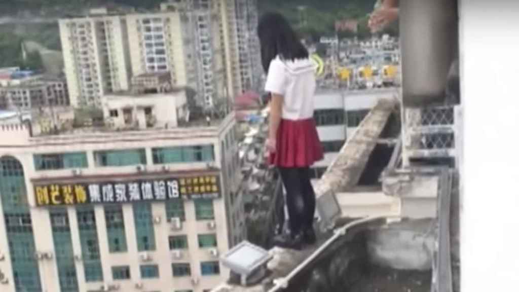 La alumna en el borde del edificio junto al profesor