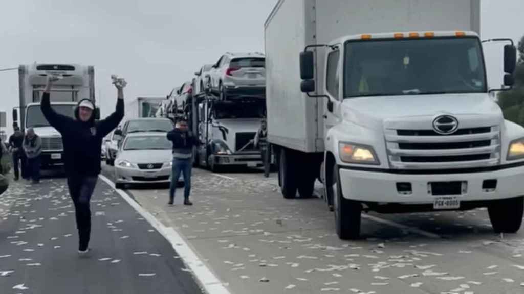 Un joven recoge dinero del suelo de una autopista /REDES