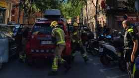 Los bomberos frente al edificio de Badalona desde el que saltaron dos menores para huir de un incendio / BOMBERS