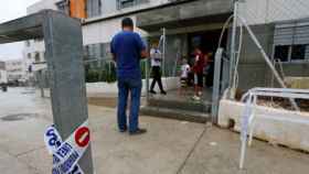 Entrada al edificio donde se encontraron los cuerpos de los padre y el hermano del presunto homicida / EFE