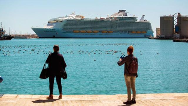 Dos turistas ven la llegada de un crucero en el puerto de Málaga esta Semana Santa / EFE