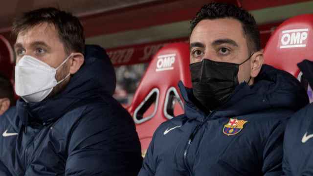 Xavi Hernández junto a su hermano Óscar en el banquillo / EFE